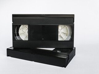 Close-up of a video cassette standing on top of another video cassette isolated on a white background