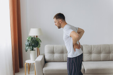 Back pain, kidney inflammation, man suffering from backache at home, health problems concept