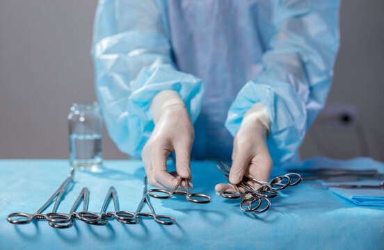 Nurse arranging surgical tools over operating table in hospital