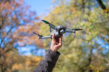 A man holding a drone towards the sky.