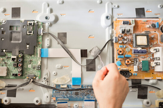Hand of man repairing TV at home