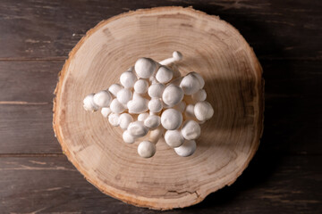 Closeup of a bunch of shimeji mushrooms on wooden background, with selective focus