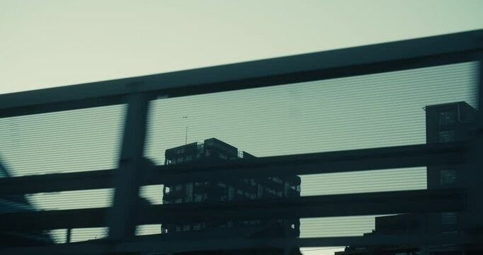 Panning shot from outside car, bus or train window or bicycle on high-rise office corporate buildings in modern neighbourhood in barcode, bjorvika in Oslo, Norway on a moody grey winter day