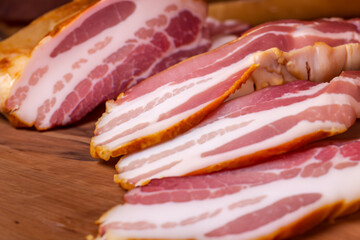 Obraz premium A wooden with meat and bacon. Food meal cuisine concept. Two slices of bacon lie on a wooden . A plate of meat, bacon and cheese lies on lifestyle a wooden.