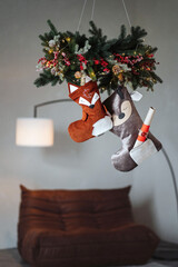 Obraz premium Whimsical Christmas stockings in the shape of woodland animals like deer, foxes, hang as charming holiday decor. Their cozy, handmade designs add a playful and rustic touch to the festive atmosphere.