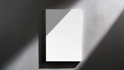 Typical vertical white rectangle poster mockup with diagonal window shadow on smooth gray concrete wall. Flat lay, top view. Open design.