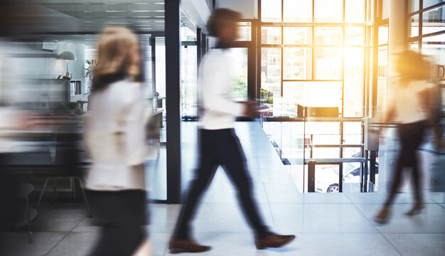 Business people, walking and speed with busy office for productive company, movement or rush. Group, employees or fast team moving with motion blur in lobby or hallway for staff meeting at workplace