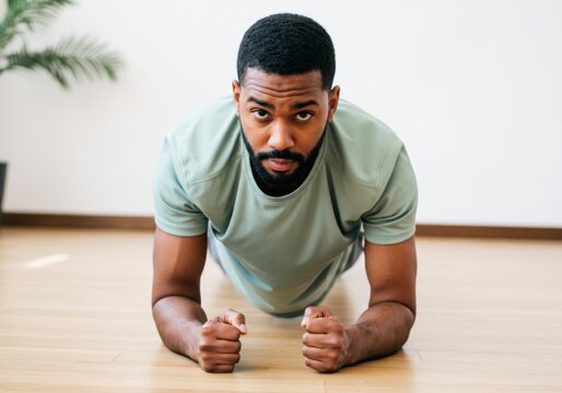 Focused man practicing plank exercise for core strength in cozy home environment