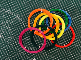 Prepared rings of plastic filaments on the basis of the marked drawing. Colored threads for 3D printing using a portable pen.