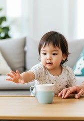 Curious baby reaching for a mug in a cozy living room setting