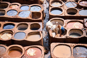 People works in the Shuara leather dyeing factory. Traditional Moroccan craft.