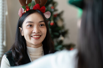 Festive Christmas Office Celebration with Decorated Tree and Happy Employee in Reindeer Antlers