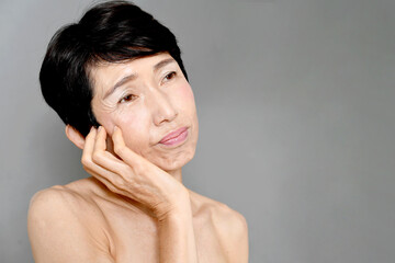 肌のトラブルで悩む中年のアジア人女性