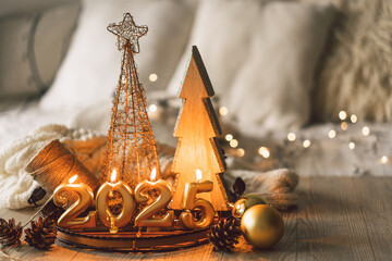 The arrangement features golden numbers representing 2025, lit candles, and a Christmas decor, creating a festive atmosphere in a cozy setting perfect for New Year celebrations.