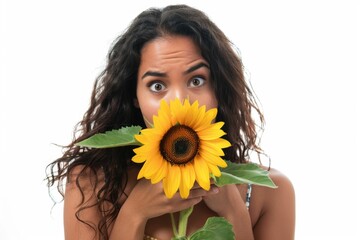 A woman holds a sunflower in front of her face, creating a unique and intriguing scene