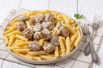 Ground chicken meatballs with penne pasta on plate