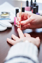Obraz premium Woman having a manicure and painting her nails at home
