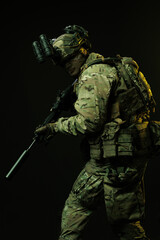 Side Profile of Soldier in Tactical Gear with Rifle and Night Vision Goggles