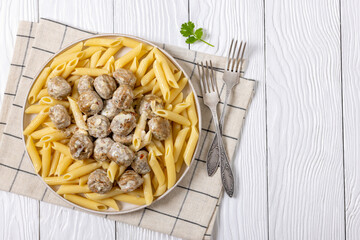 Ground chicken meatballs with penne pasta on plate