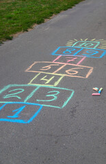 Children jumping hopscotch on the street. Selective focus.
