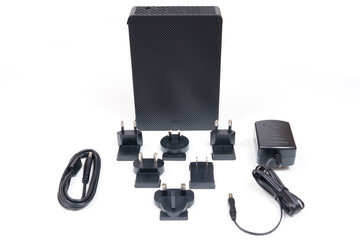 Naklejka premium External HDD with Multiple International Adapter Plugs on White Background