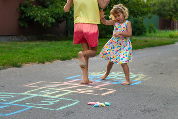 Children jumping hopscotch on the street. Selective focus.