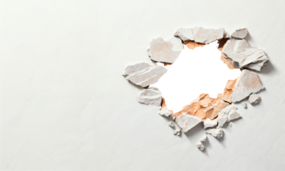 A dramatic view of a broken wall showcasing rough textures and colors, creating a striking contrast between exposed material and pristine surface, evoking intrigue and curiosity.