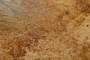 Scratched and dirty, oil stained burn marks on metal pan bottom. Close up macro shot, background texture, no people