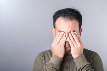 Man covers his eyes with both hands, symbolizing the vision complications from diabetes, known as diabetic retinopathy. Highlights the importance of awareness and eye health in diabetes care