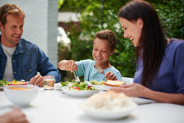 Happy family, holiday and thanksgiving dinner with kids, festive and food for celebration or vacation. Group, people and backyard with love at party, table and nutrition for gathering, event and home