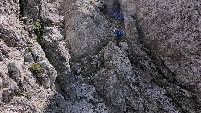 Man climbs rocky mountain, summer, Grignetta, Italian Alps. Aerial lateral drone