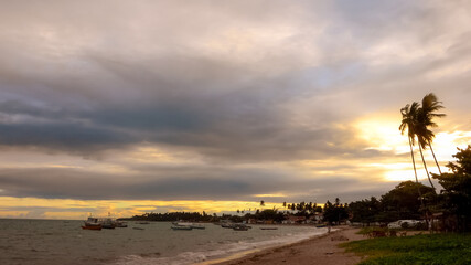 ITAPARICA, BAHIA STATE, BRAZIL: colorful sunset above small fishing village at the beach, 