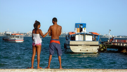 ITAPARICA, BAHIA STATE, BRAZIL: young african-american couple standing up together and watching...