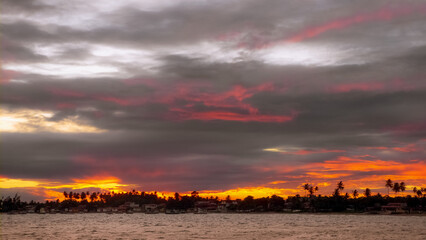ITAPARICA, BAHIA STATE, BRAZIL: colorful sunset above small fishing village at the beach, 