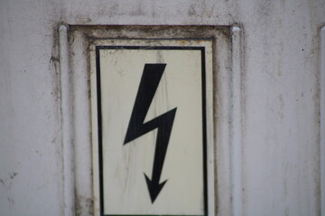Warning sign indicating electric hazard on a building's exterior, emphasizing safety in an urban location