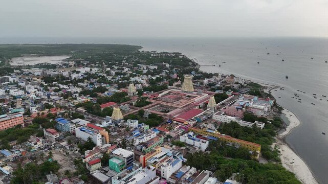 This aerial video showcase Ramanathaswamy Temple in Rameshwaram serene atmosphere within the temple, with devotees offering prayers and performing rituals. the sacred Agni Theertham location