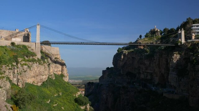 Locked shot of the Sidi M'Sid bridge with a couple of pedestrians crossing, Constantine, Algeria