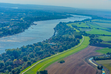 Fototapeta premium Aerial view of valley with farm fields, pond and Danube river. High quality photo