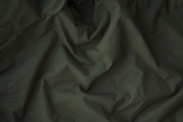 Texture of Dark green military uniform textile cloth with folds