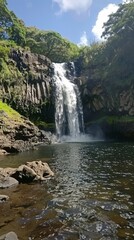 Fototapeta premium The serene beauty of a cascading waterfall in a dense jungle setting, where nature's music and lush foliage create a tranquil haven.