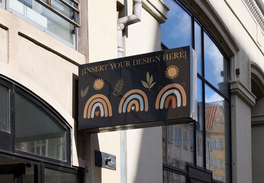 Black Customizable Hanging Sign on a Business Facade. Surface with real reflections in Copenhagen on a Business Facade. Customizable Mockup