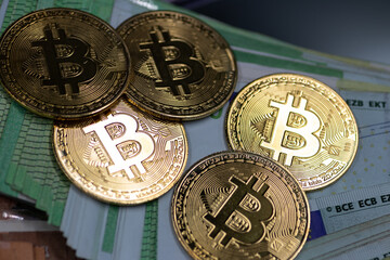 Golden Bitcoin coins, arranged alongside a pile of Euro notes, symbolizing the interplay between traditional and digital currency in modern finance