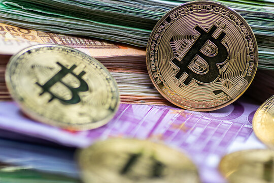 Golden Bitcoin coins, arranged alongside a pile of Euro notes, symbolizing the interplay between traditional and digital currency in modern finance