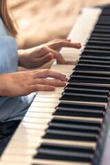 Fototapeta premium Female hands on the piano. The girl plays the piano. Musical instrument.