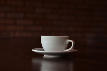 The coffee cup is on the table. It's hot.