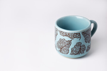 Light blue cup with floral motif on white background