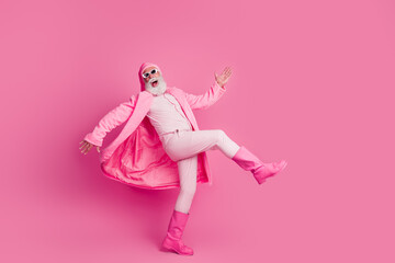 Photo of crazy excited glad funny man wear stylish bright coat boots walk store mall center isolated on pink color background