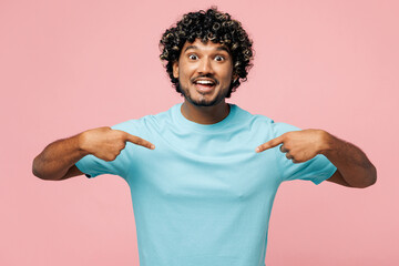 Young shocked surprised happy Indian man he wear blue t-shirt casual clothes point index finger on himself look camera isolated on plain pastel light pink background studio portrait Lifestyle concept