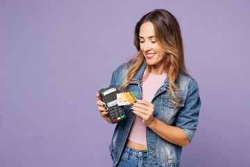 Young woman wear denim jacket violet top casual clothes hold wireless modern bank payment terminal...