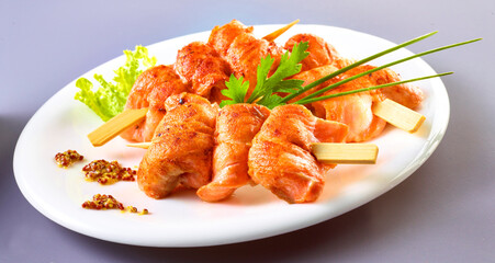 Lachsspiesse mit Petersilie und Schnittlauch auf weissem Porzellanteller, Fisch, gebraten, Lachs, Holzspiess, 